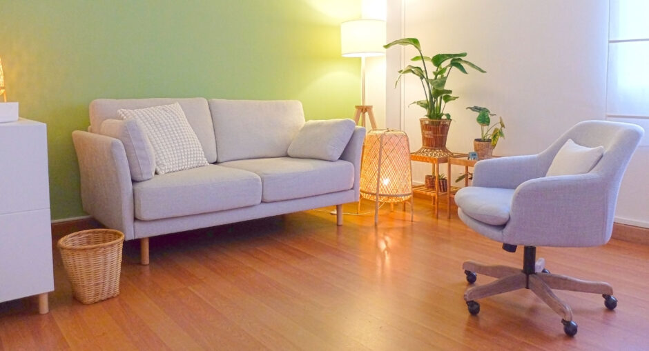 Consulta de psicoterapia con sofá y planta